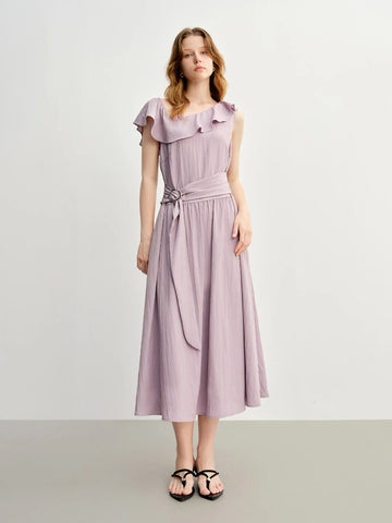 Woman wearing a light purple dress with ruffled collar on a white background