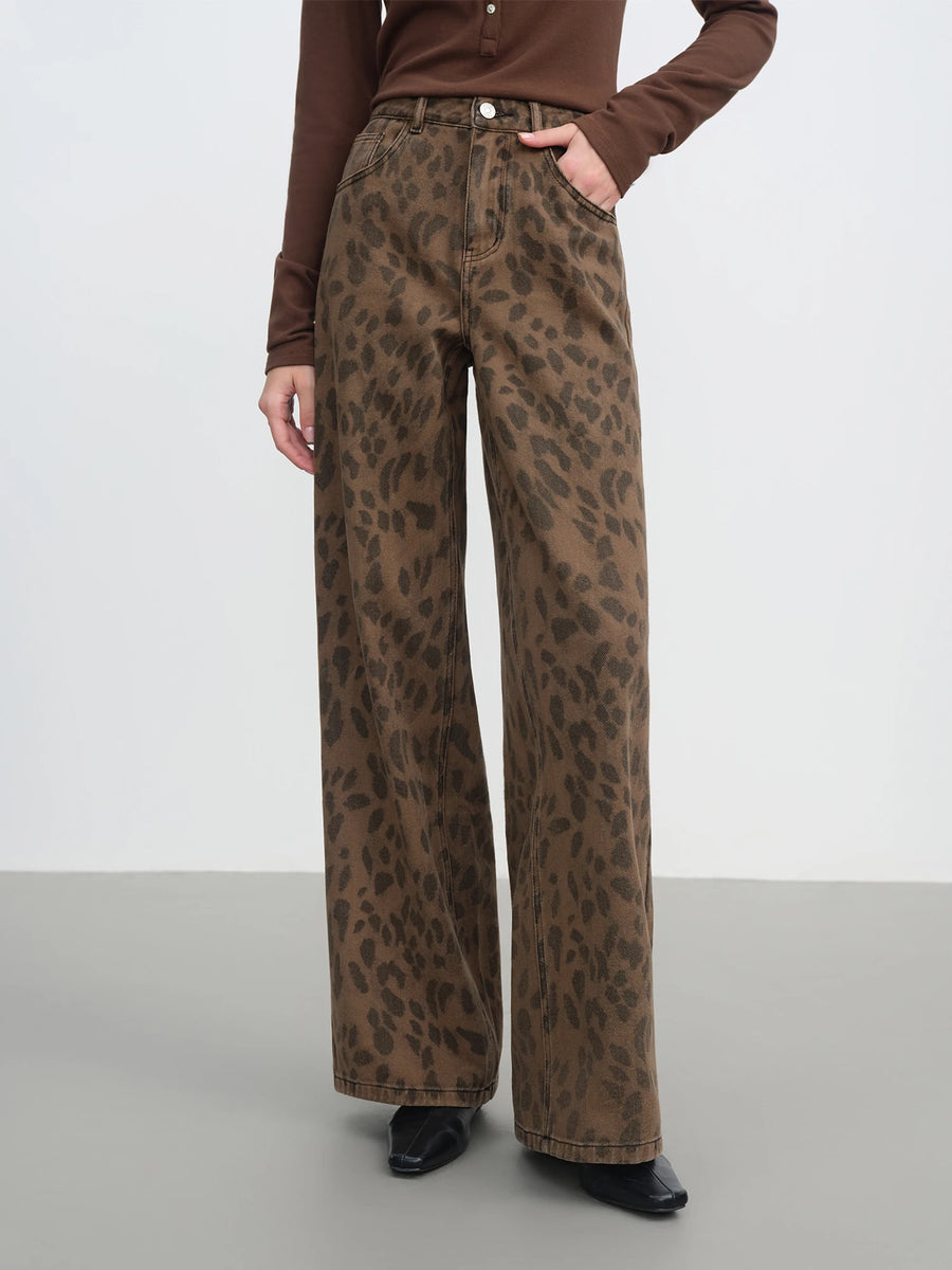 Person wearing leopard print pants on a plain background