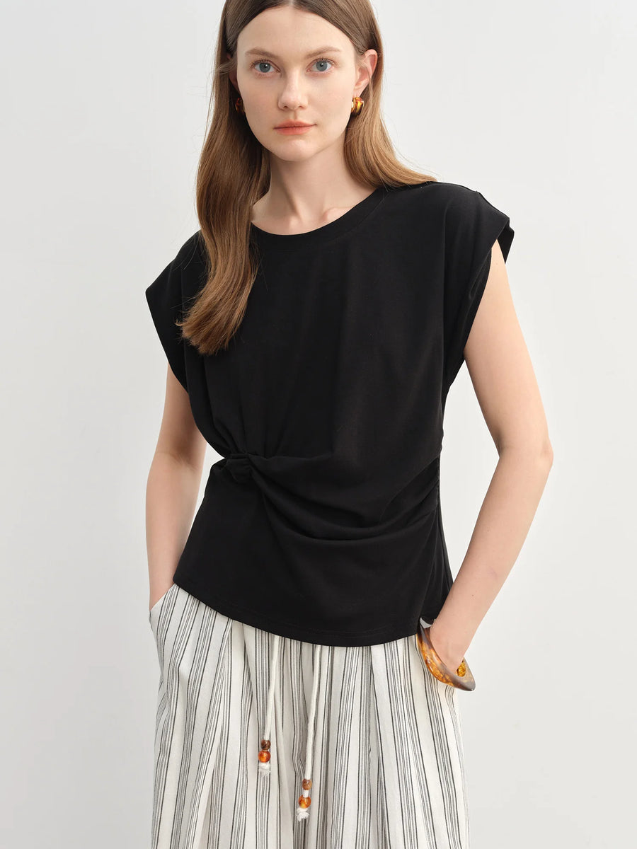 Woman wearing a black top and striped skirt on a light gray background