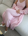 Person wearing a pink dress sitting on a couch.