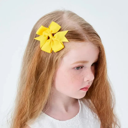 Young girl with a yellow hair accessory on a white background