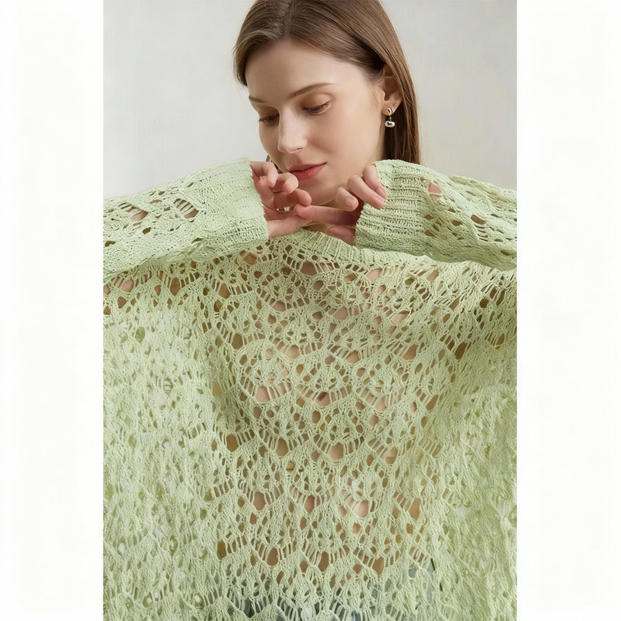 Woman wearing a green lace sweater with 'AMII' branding.