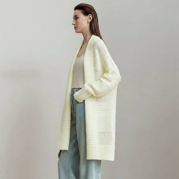 Woman wearing a light yellow knitted cardigan on a gray background with AMII branding.