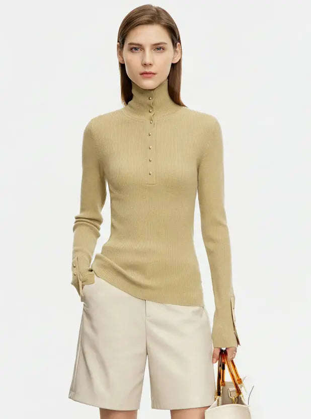 Woman wearing a beige long-sleeve top and white shorts on a light gray background